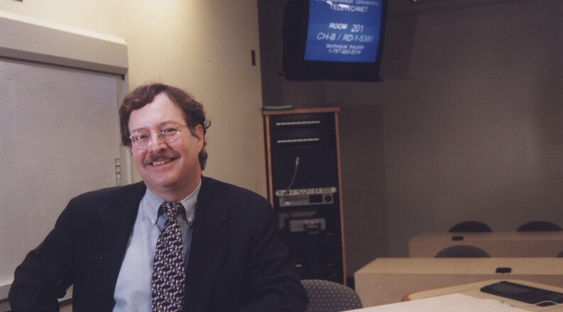 Dr. Stephen W. Tonelson, Special Education instructor, at a distance learning broadcast studio located in the Gornto Teletechnet Building.