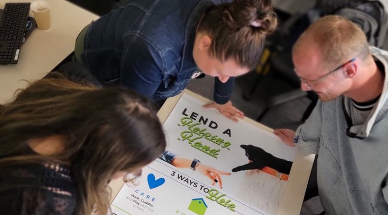 Image of faculty and students reading a poster