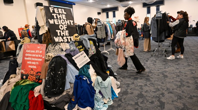 Students browse clothing racks. 