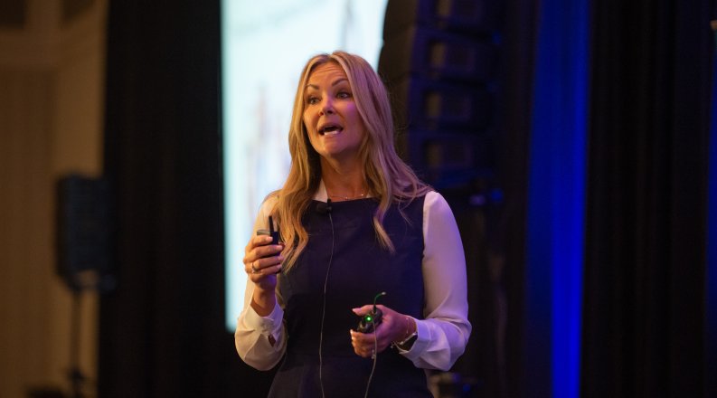 A woman presents in front of a screen at the 2022 State of the Region event.