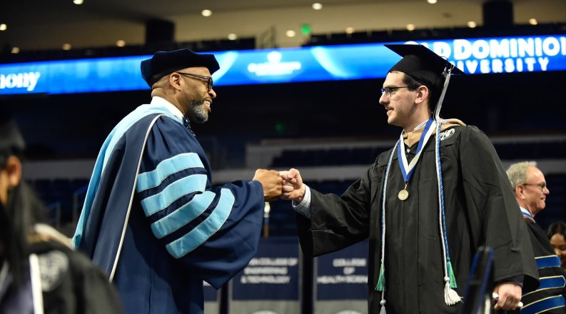 ODU President Brian Hemphill congratulates a Strome business graduate during commencement cermony