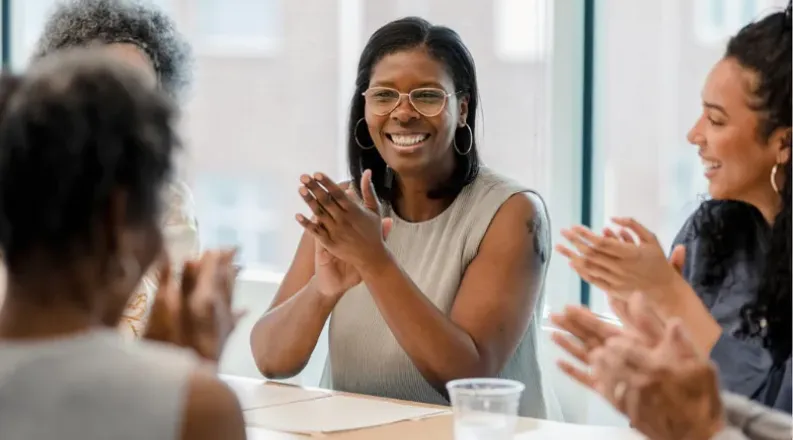 Smiling woman surrounded by colleagues in professional setti