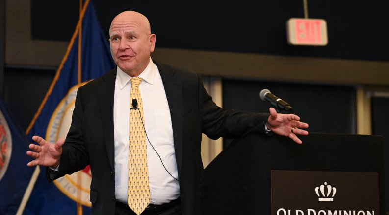 A man stands in front of a podium.