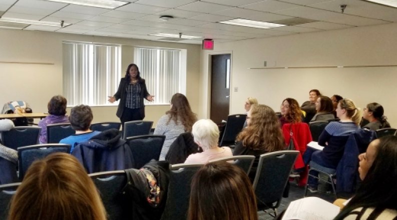 Women teaching in front of class. 