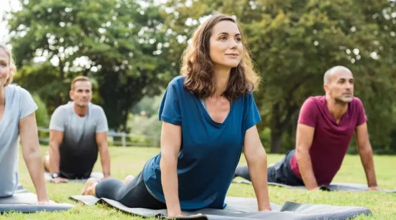 Group of people doing yoga outdoors
