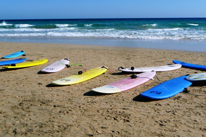 Surfboards lie on the beach.