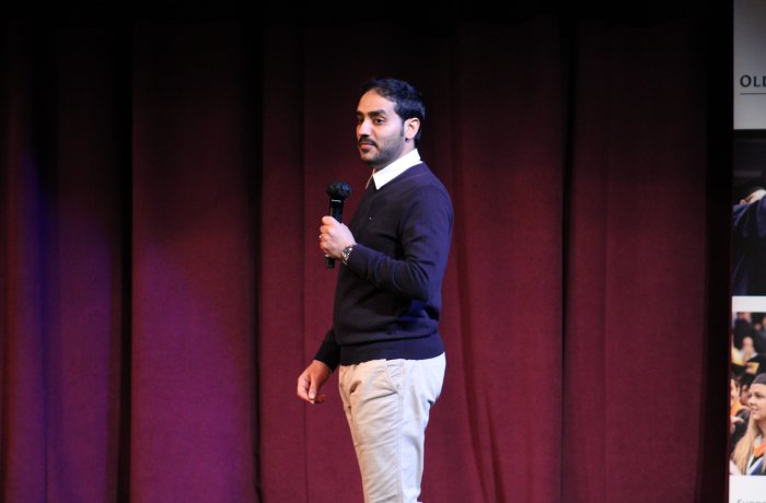 A man speaks on a stage.