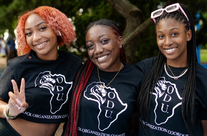Three students standing together smiling