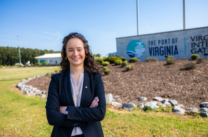 Finley Stoops stands in front of Port of Virginia sign. 