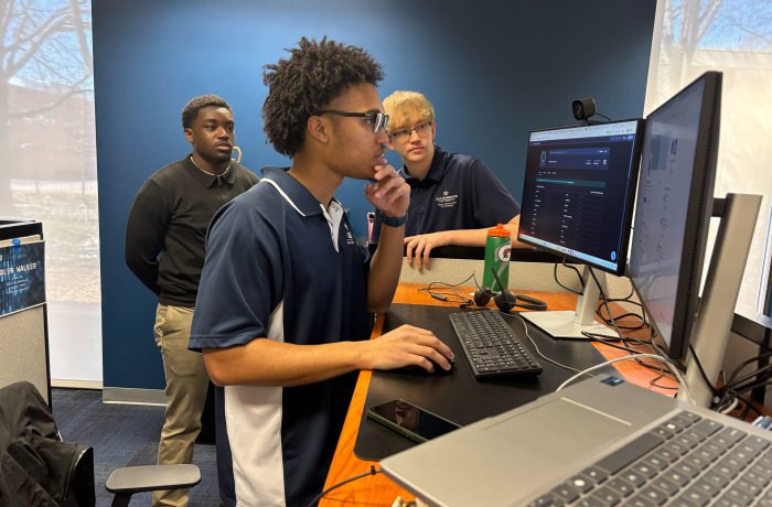 Three people at a computer