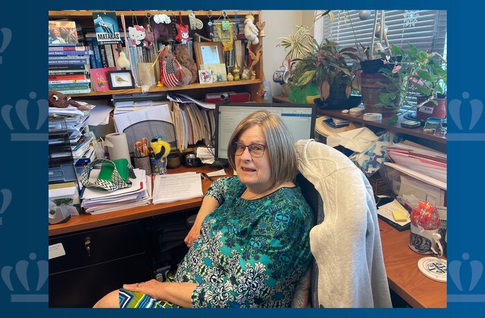 Fran Hassencahl, Ph.D., is shown seated in her Batten Arts and Letters Building office, surrounded by scholarly books, thriving plants and colorful toys.