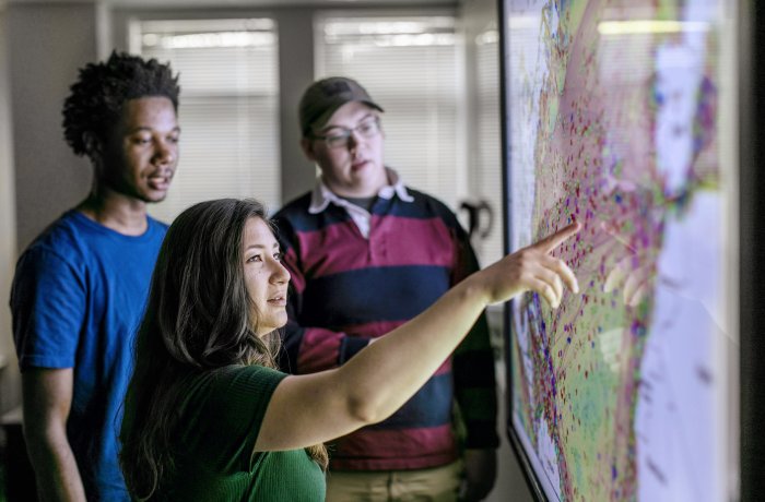 3maritime students work in front of map