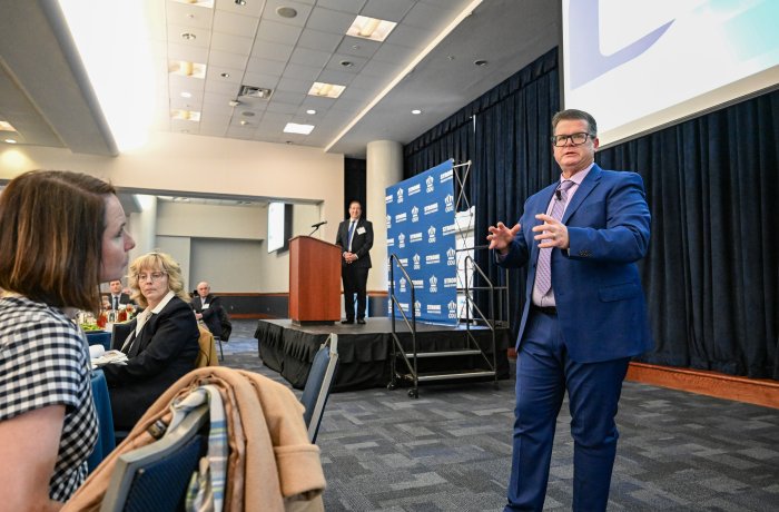 A man talks to a crowd of people.