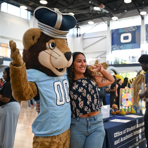 Big Blue with a student at the Resource Fair in the gym.