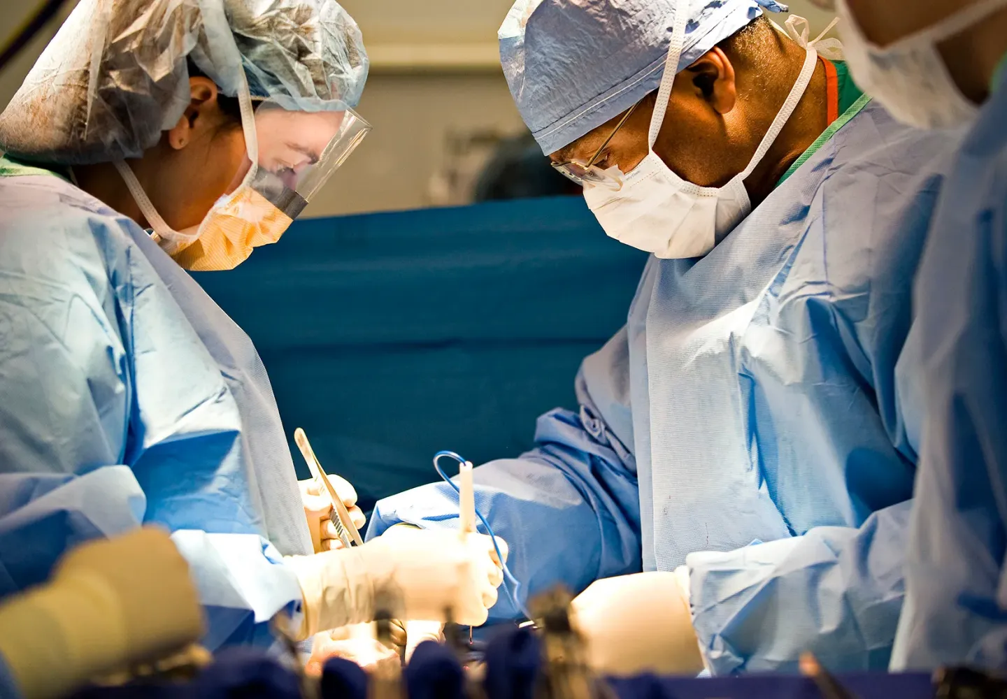 Doctors in operating room perform surgery on patient.