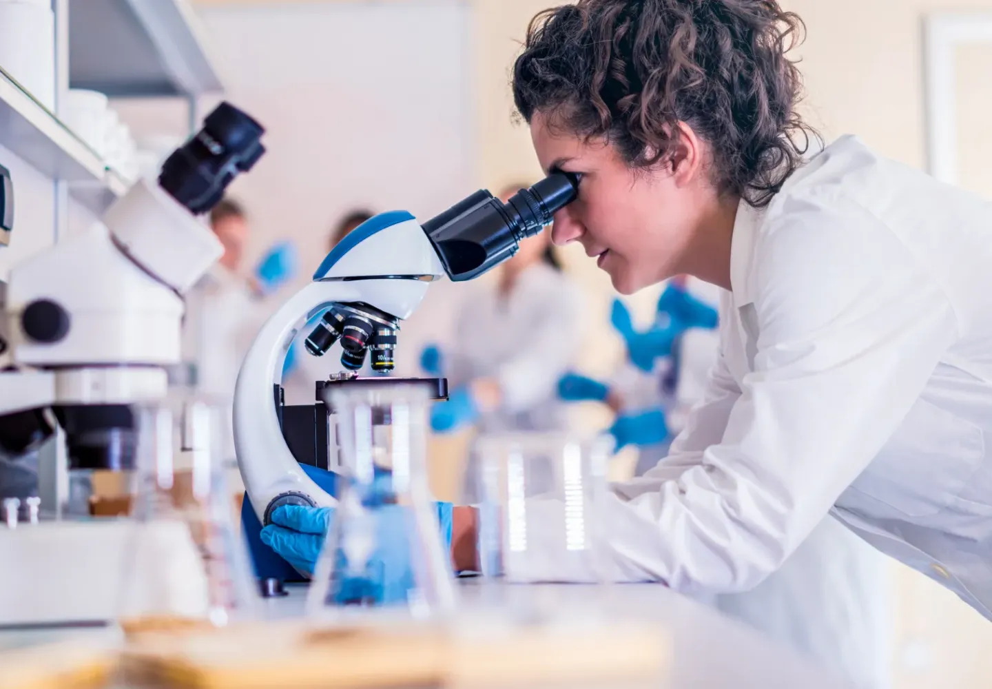 A student looking into a microscope in a lab