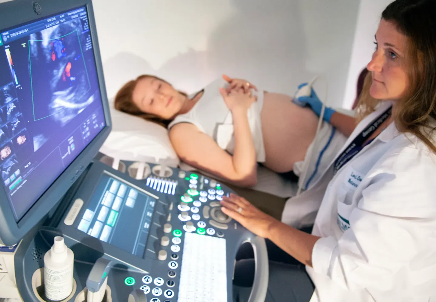 An ultrasonographer performs an ultrasound on a pregnant pat