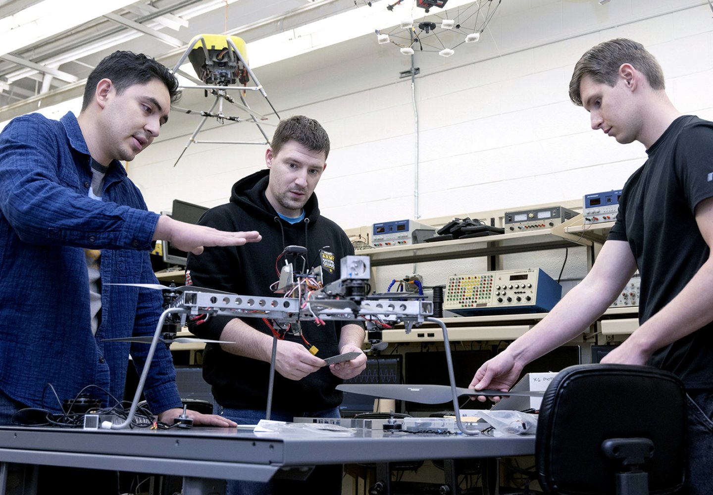 Three students working on a drone