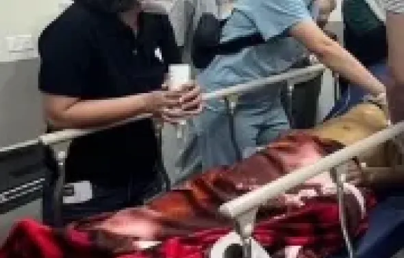 Global Emergency Medicine gather around a patient on a stret