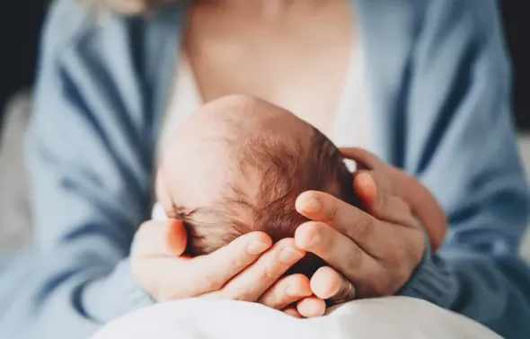 Newborn in mother's hands.