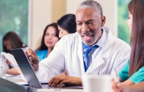 A medical teacher works one-on-one with a student