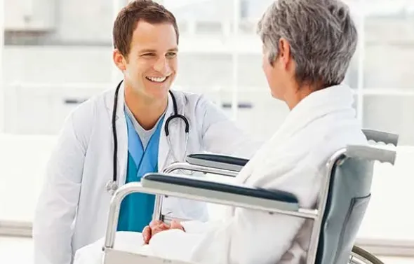 A resident talks with a patient.