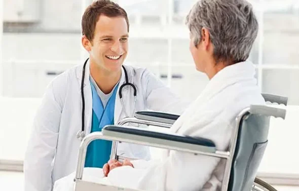 A resident talks with a patient.
