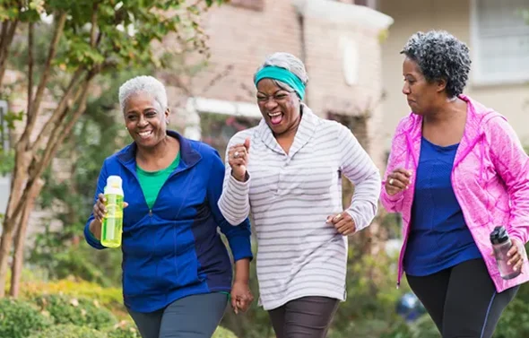 Three women walking on a suburban sidewalk in athletic cloth