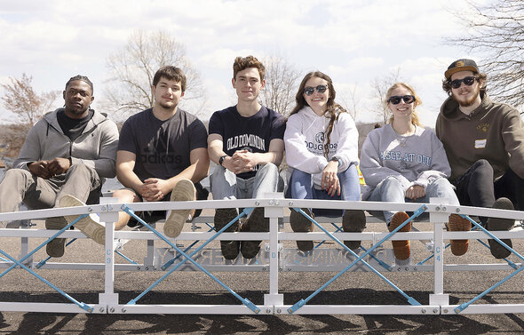 civil engineering students sit on top of their ASCE competition bridge.