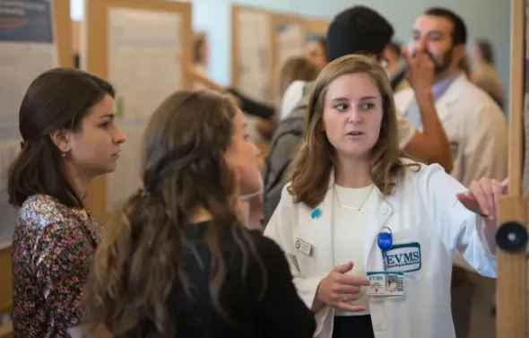 A picture of a medical student explaining her research poste