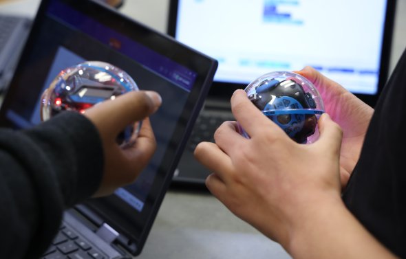 two students holding orbs