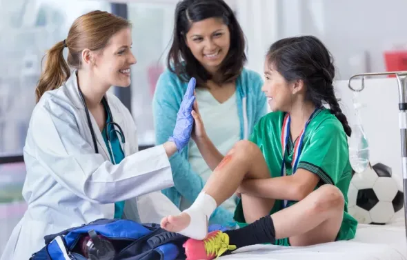 Doctor and an elementary age female patient high five one an