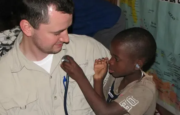 A child listens to a fellow's heartbeat through a stethoscop