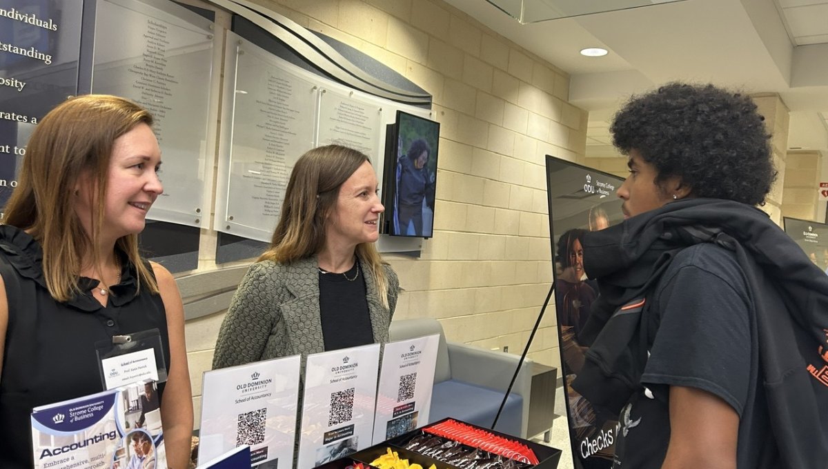 student meeting faculty at a booth
