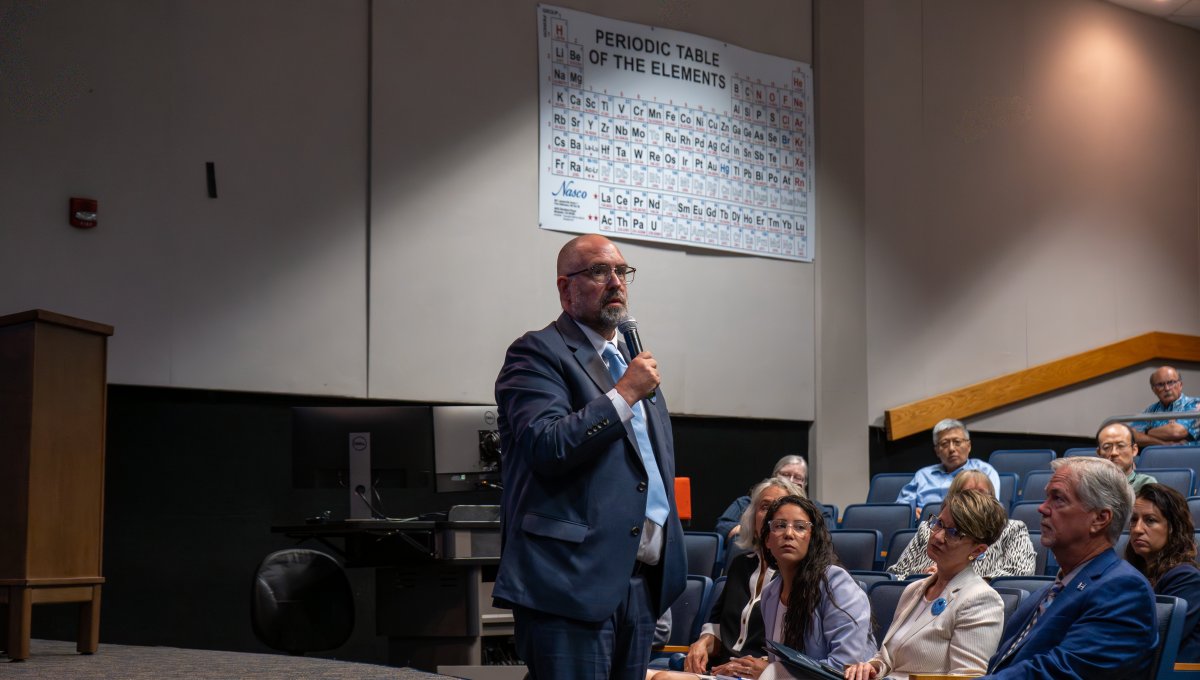 Provost and Vice President for Academic Affairs Brian Payne stands on stage while holding microphone welcoming College of Sciences faculty and staff for the 2025-2026 academic year.