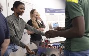 Black female student holding her hands out to man stopped at her booth