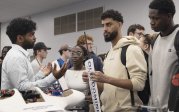 Male Indian student explains his presentation to two onlookers