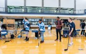 A group of students holding hockey sticks. 
