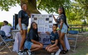 A group of girls pose for a photo in front of an informational table. 