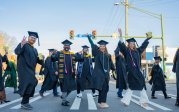 A group of students cross the street.