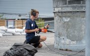 Student cleaning part of ship