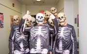 A group of students dressed in skeleton costumes pose for a photo.