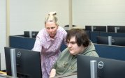 Woman and student look at computer