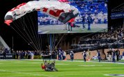 The Patriot Parachute Team, made up of former Navy SEALs as well as their canine companion, a Frog Dog K9, parachute onto the field before the game.