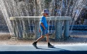 A kid walking by the lion fountain.