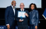 Chief Garrett Shelton holds award while posing for picture with ODU President Brian O. Hemphill.