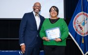 Evette Brooks holds award while posing for picture with ODU President Brian O. Hemphill.