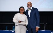 Georgea Carroll holds award while posing for picture with ODU President Brian O. Hemphill.