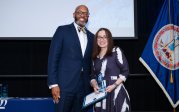 Maite Wilson holds award while posing for picture with ODU President Brian O. Hemphill.