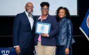 Millicent Lee holds award while posing for picture with ODU President Brian O. Hemphill.